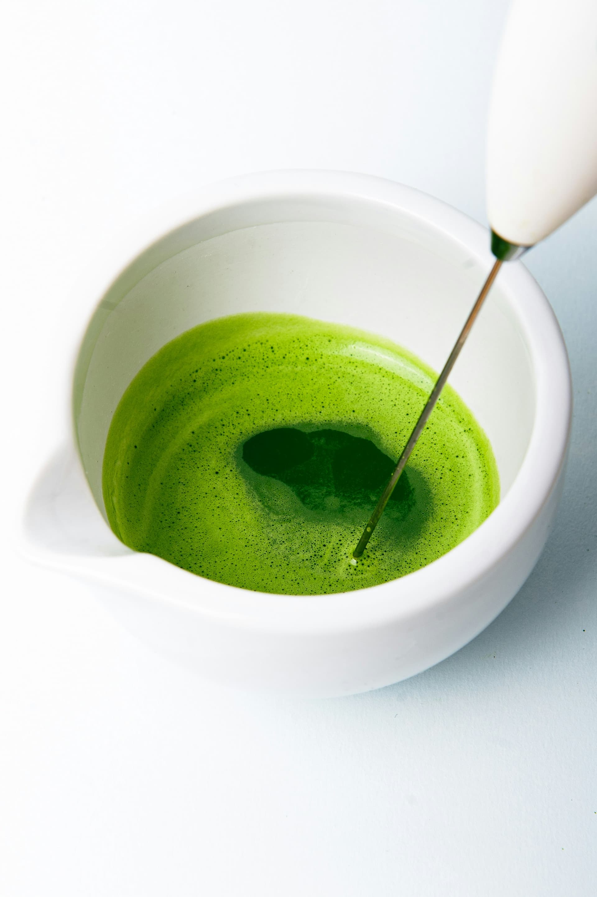 Matcha being whisked in a bowl
