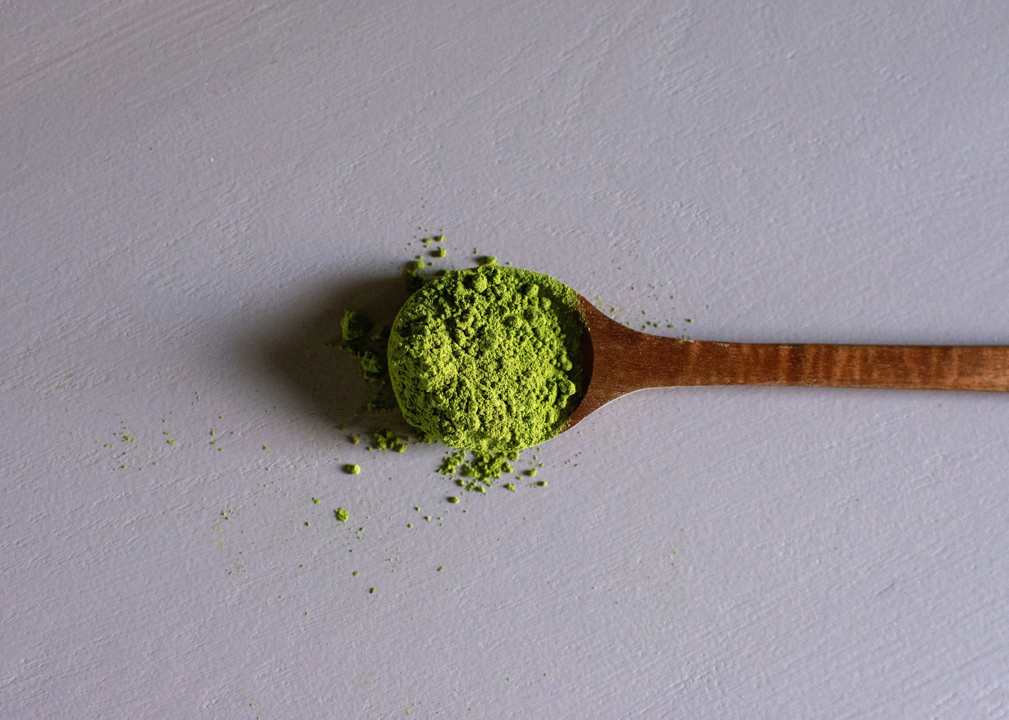 木のさじにのる抹茶の粉